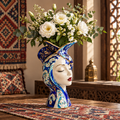 Moroccan lady face ceramic vase with white roses and baby's breath beside Moroccan lattice window and lantern