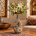 Persian cut-out teardrop ceramic vase with white lilies and baby's breath beside Moroccan lattice window and lantern